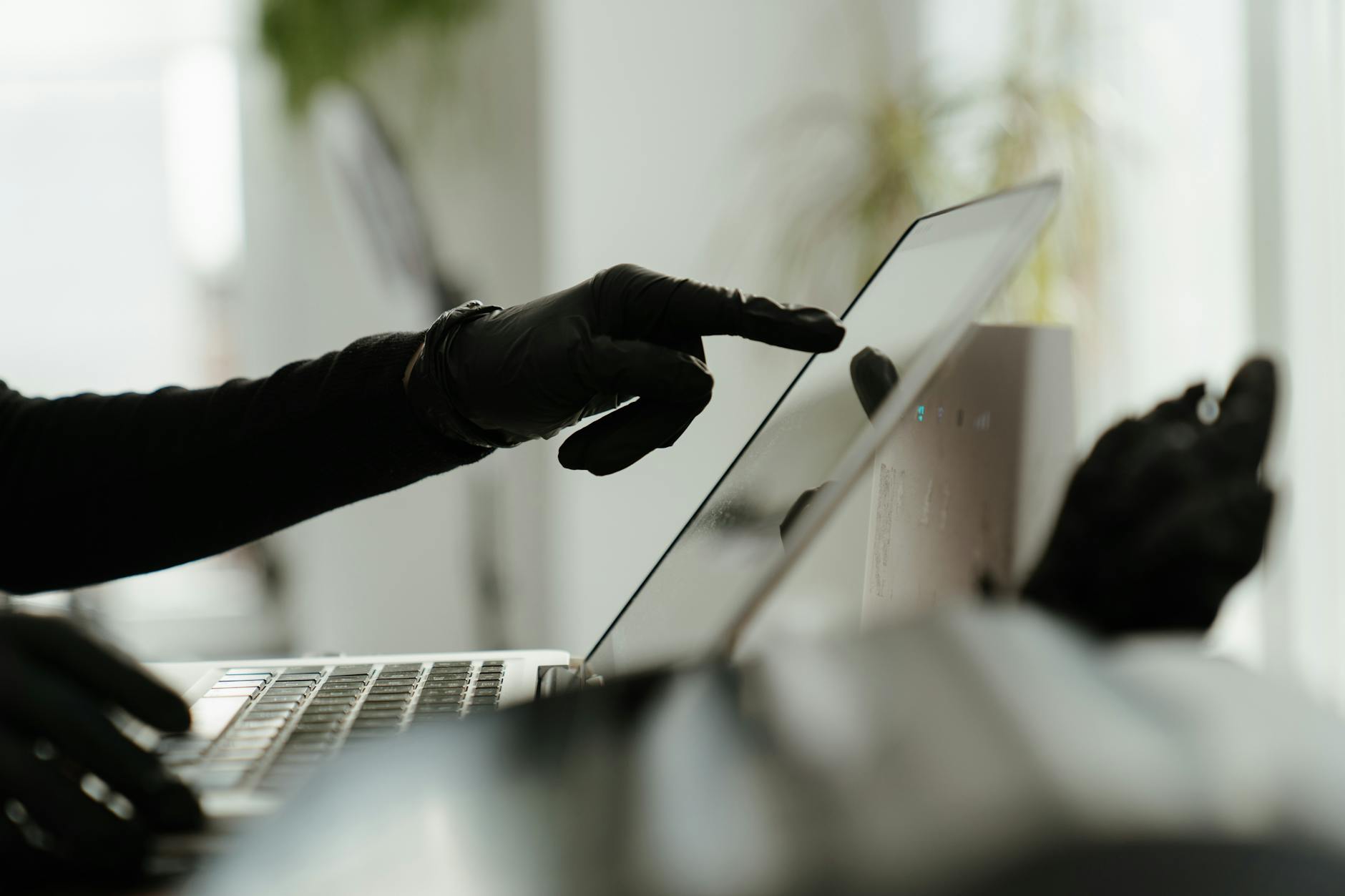 person in black pants and black leather boots using macbook pro